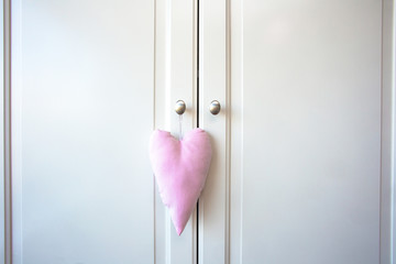 White doors of cupboard and pink decoration heart. retro wooden design background texture
