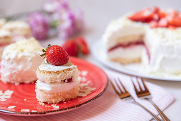 Torte und Törtchen mit Quark und Sahne und weißer Schokolade und Erdbeeren