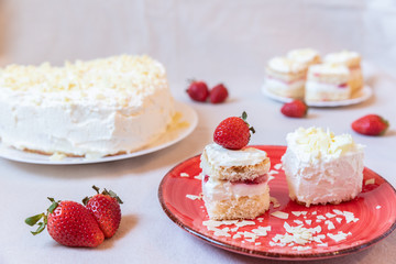 Torte und Törtchen mit Quark und Sahne und weißer Schokolade und Erdbeeren
