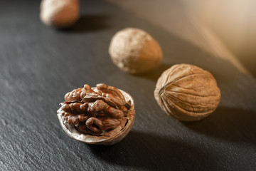 Whole walnuts on dark board.