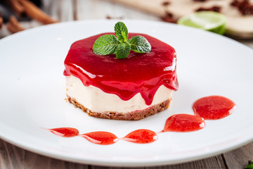 Side view closeup on sweet dessert strawberry cheesecake jam and mascarpone on a white plate, horizontal format