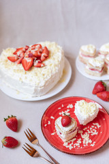 Torte und Törtchen mit Quark und Sahne und weißer Schokolade und Erdbeeren