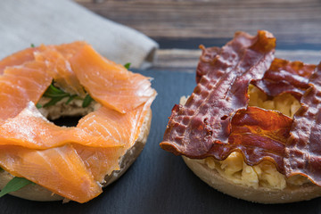 Salmon bagel and bacon bagel on a slate plate. Close up view.