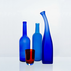 Still life with colored bottles on a white background