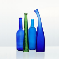 Still life with colored bottles on a white background