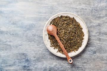 Dried Green Tea Leaves on Bright Background. Top view. Close up. Copy space.