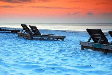 Wooden chairs await relaxers along the Gulf of Mexico Shore in Pensacola, Florida
