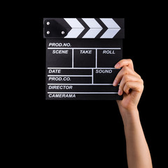 Fototapeta na wymiar Human hand holding film clapper board isolated on black background