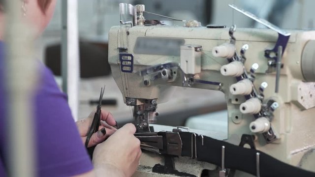 A woman sews at the factory of disposable mask