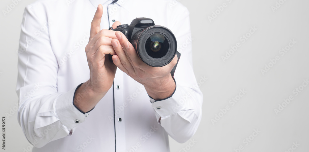 Poster camera in hands of a man in white clothes with copy space