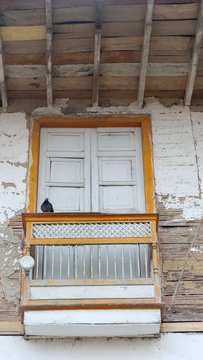 white window with small porch in old house built of bahareque and wood