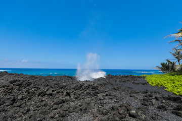 Blow Hole in Hawaiian State Park on the Road to Hana Maui Hawaii with Volcanic Rock and Blue Pacific Ocean