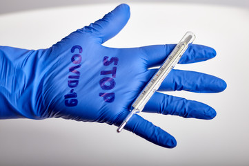 medical blue rubber glove with the inscription stop covid19