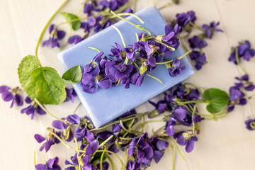 Obraz na płótnie Canvas viola violetta odorata skin care product fragrant lilac soap with lilac spa bath salts and tincture body oil 