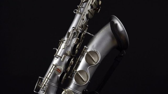 Wind Instrument Saxophone On A Black Background.