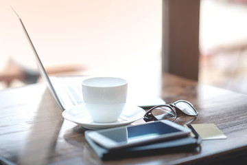 Laptops, notebooks, coffee cups and watches placed on the desk