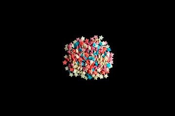 multicolored confectionery sprinkle in the form of stars on a black background