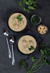 Bean soup-puree with meatballs, dill, parsley in a bowl on a dark background top view