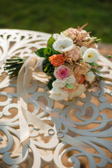 Bridal bouquet of roses and rings on natural background.