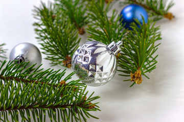 New year and christmas decoration with green fir tree branches and blue and silver shiny xmas traditional balls and baubles for greeting invitation cards.
