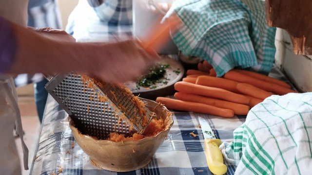 H&auml;nde reiben Karotten in der K&uuml;che eines alten Bauernhofs