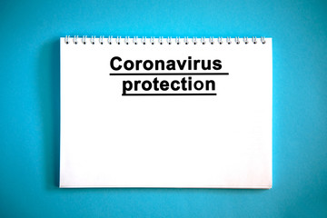 Coronavirus protection - text on a white notebook on a blue background
