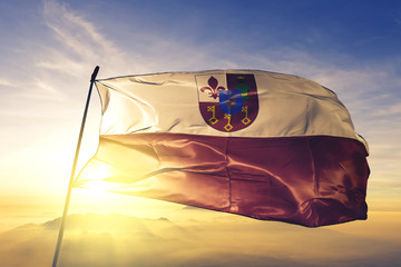 Waregem of West Flanders of Belgium flag waving on the top sunrise mist fog