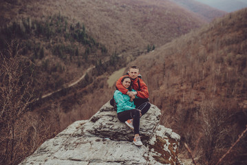 Fototapeta premium Young couple sitting near the cliff