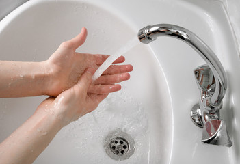 Person washes their hands with soap and clean tap water to remove dirt, bacteria and viruses....