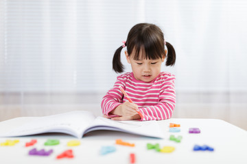 toddler girl practice writing letters for homeschooling