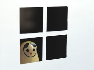 Russian doll matryoshka in the window looking on the street. Toy representation of confinement,...