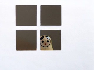 Russian doll matryoshka in the window looking on the street. Toy representation of confinement,...