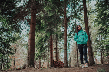 Portrait of a beautiful hispanic woman hiking in the pine forest alone, a solo expedition camping trip
