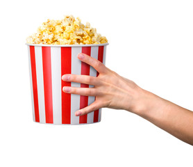 Woman hand holding striped bucket with popcorn isolated on white background