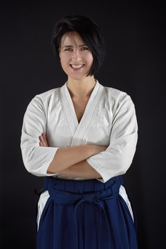 Portrait aikido master woman wearing traditional samurai hakama clothes. Isolated on black Background