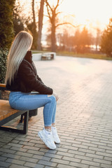 young beautiful girl sitting on bench in park