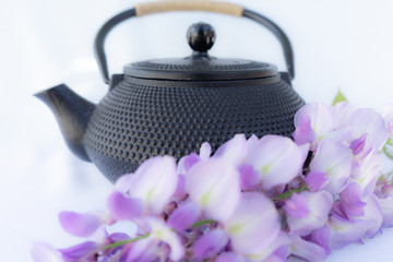 Obraz na płótnie Canvas Japanese teapot with purple flowers on a white background