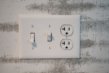 Electrical outlet socket with light switches and grounded North American plugs.