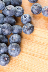 Fresh blueberry in white plate photographed against wooden background