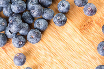 Fresh blueberry in white plate photographed against wooden background