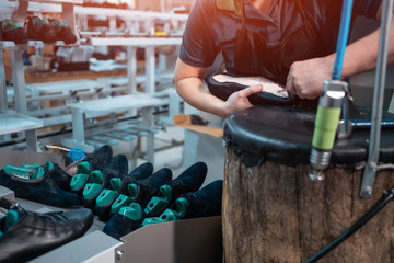 man working with automatic machinery on shoe factory