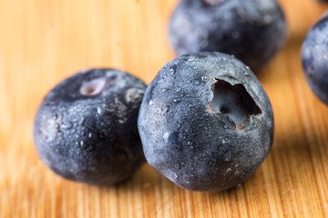 Fresh blueberry in white plate photographed against wooden background