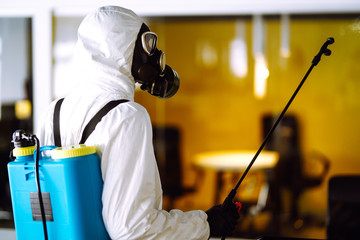 Disinfecting of office to prevent COVID-19, Man in protective hazmat suit with  with spray chemicals to preventing the spread of coronavirus, pandemic in quarantine city. Cleaning concept.
