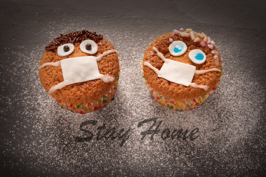two  cup cakes decorated ,face with mouth cap