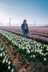 Tulip flower field in the Netherlands, young woman with dress in tulip flower field, girl with...