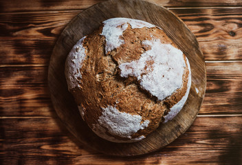 Grain Artisan Bread Loaf. Rustic loaf of homemade bread on dark wooden table. Homemade Loaf Of Bread. Lay Flat