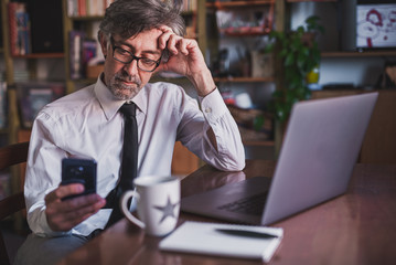 businessman working in smart working from home, thoughtful expression and worried about the future while looking at news, stock market trends, messages, focus on expression
