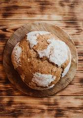 Fototapeta na wymiar Grain Artisan Bread Loaf. Rustic loaf of homemade bread on dark wooden table. Homemade Loaf Of Bread. layflat view. Vertical photo