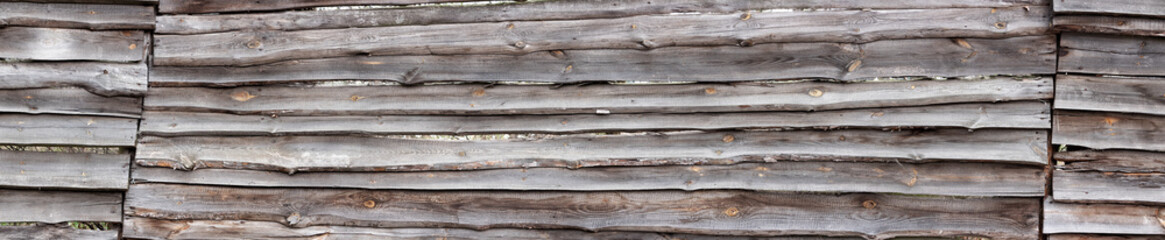 Old wide wooden fence background/ Texture of rustic fence made of planks.