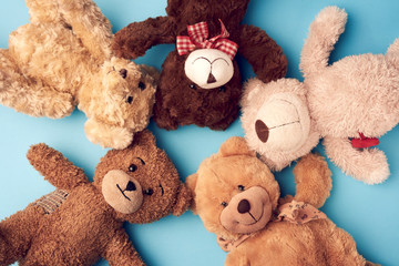 various teddy bears lie on a blue background head to head and look up